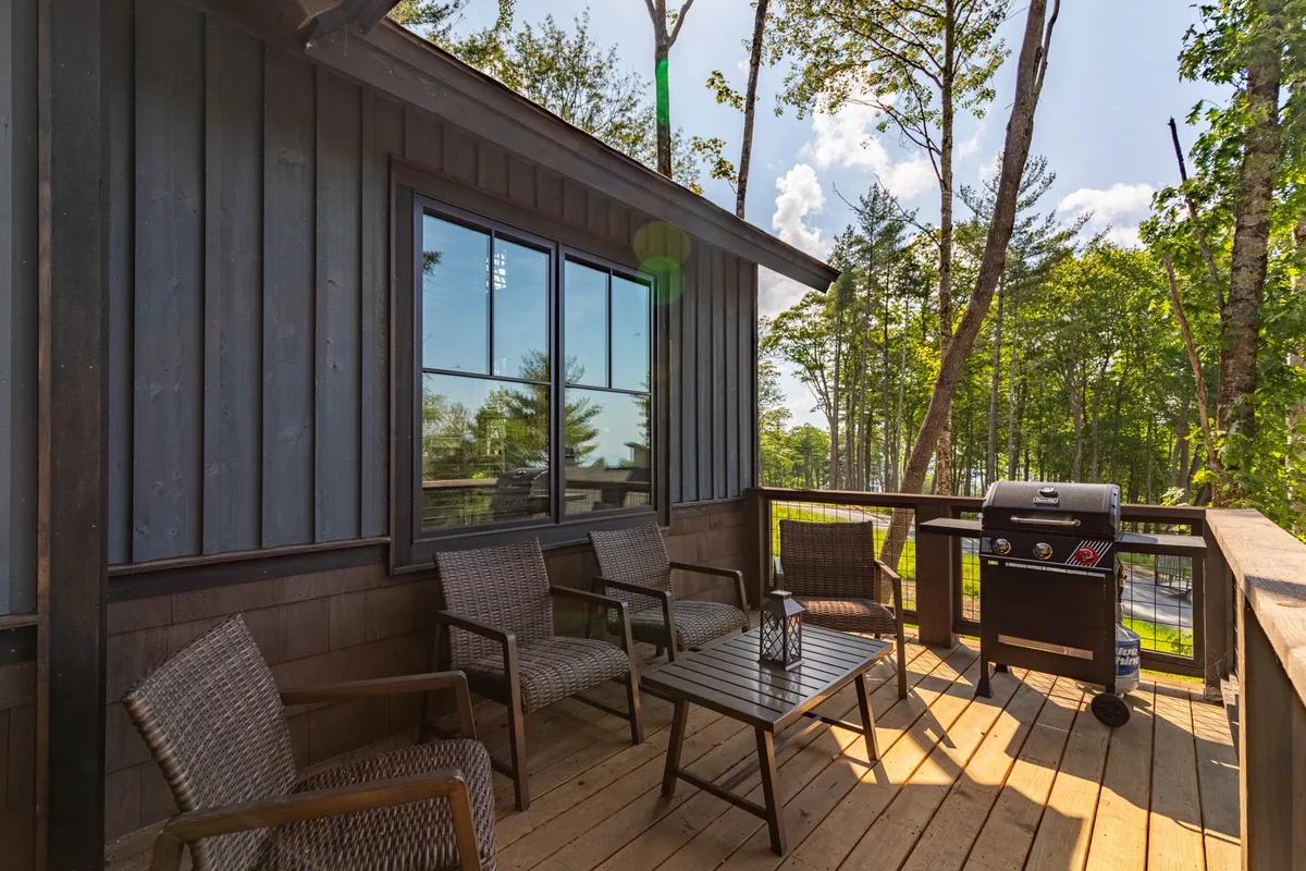 The image shows a welcoming outdoor seating area with a grill, surrounded by trees, hinting at the BBQ pavilion and casual dining mentioned in the section. The setting suggests a space for relaxing, socializing, and enjoying food and drinks in the open air.